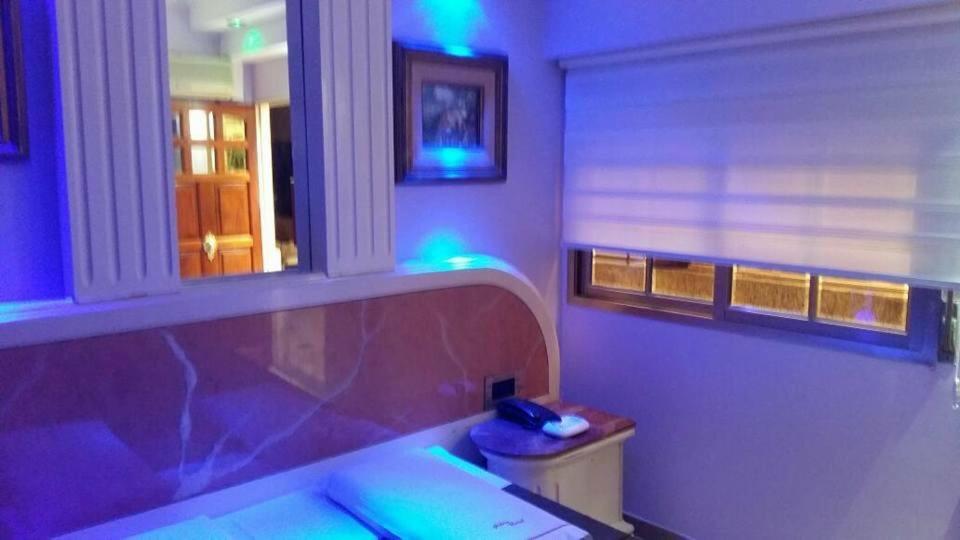 Habitación con ventana con luces moradas y azules en Hotel Gilda en Buenos Aires