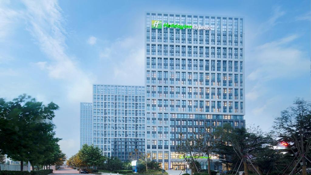 a tall building with a sign on it at Holiday Inn Express - Qingdao West Coast, an IHG Hotel in Huangdao