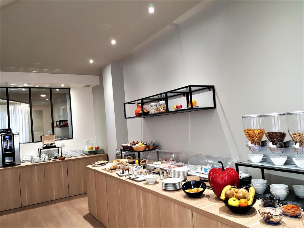 a buffet line with food on it in a restaurant at Hôtel Montaigne in Sarlat-la-Canéda