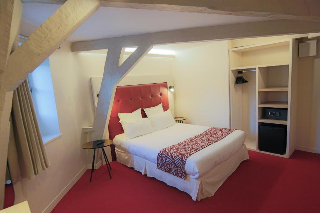 a bedroom with a large bed with a red headboard at Hôtel Montaigne in Sarlat-la-Canéda