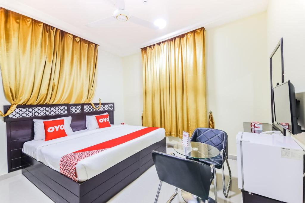 a bedroom with a bed and a desk and a tv at Ras Al Hadd Waves Hotel in Al Ḩadd