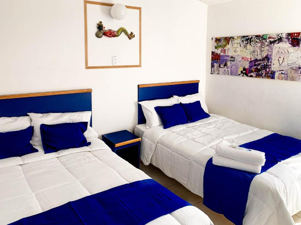 dwa łóżka w pokoju niebiesko-białym w obiekcie La Casa del Expositor w mieście Guadalajara
