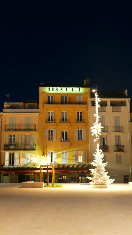 a hotel building with a christmas tree in front of it at Hotel Relais Du Postillon in Antibes