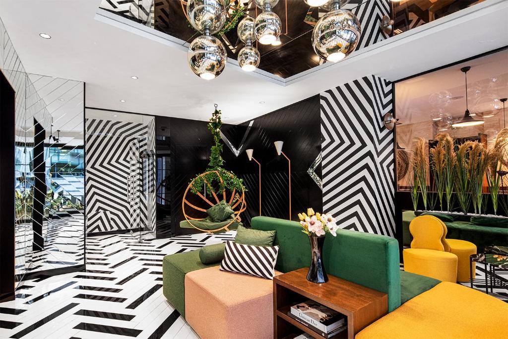 een lobby met geel en groen meubilair en een zwart-witte muur bij The Westist Hotel & Spa - Special Category in Istanbul