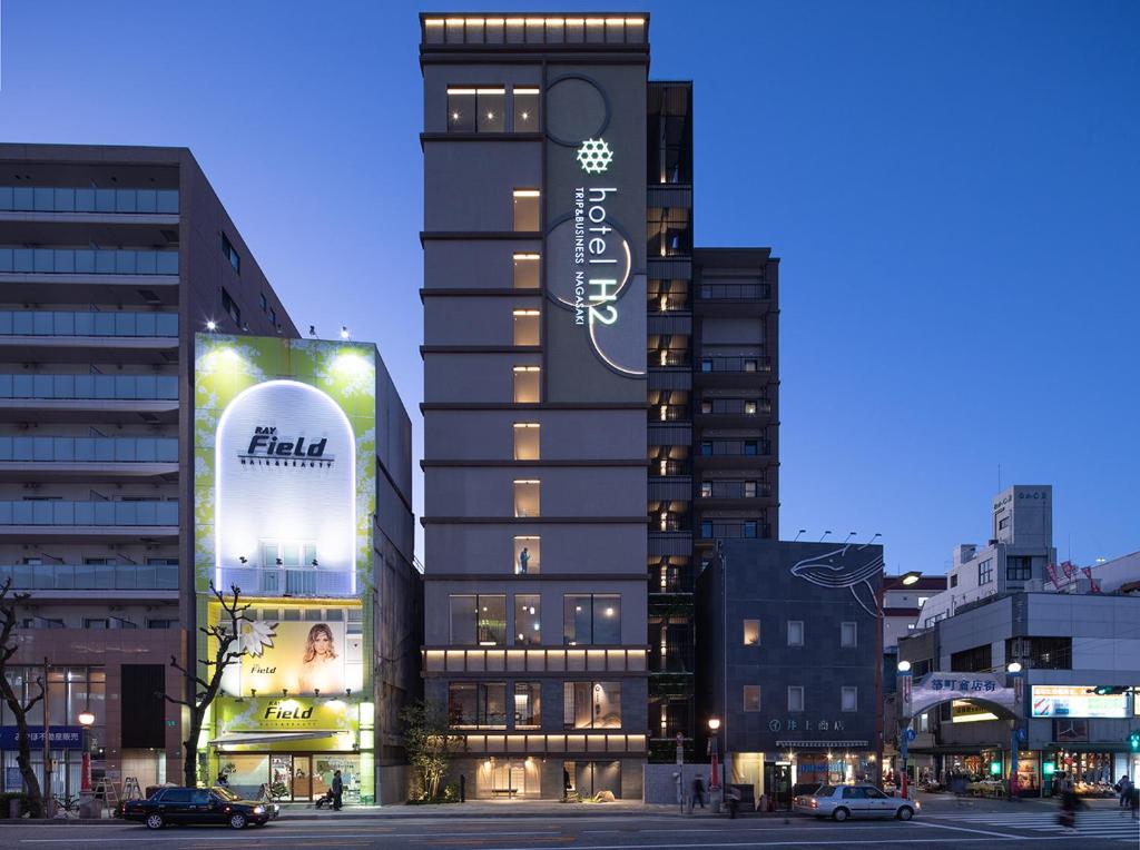 um edifício alto com uma placa na lateral em hotel H2 TRIP&BUSINESS NAGASAKI em Nagasaki