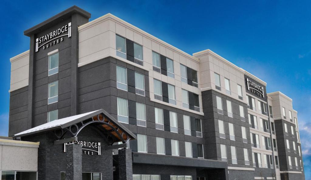Staybridge Suites - Red Deer North, an IHG Hotel في ريد دير: مبنى كبير عليه لافته للفندق