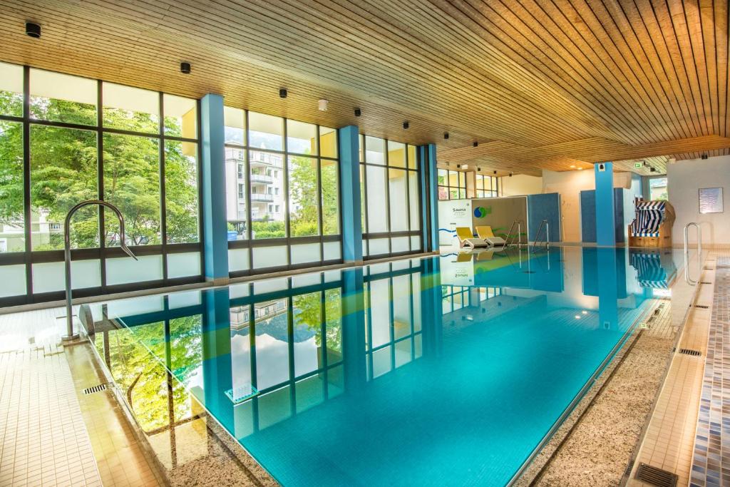 a large pool with blue water in a building at Hotel Bayern Vital in Bad Reichenhall