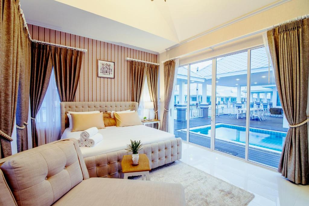 a bedroom with a large bed and a pool at Baan Marwin Hua Hin in Hua Hin