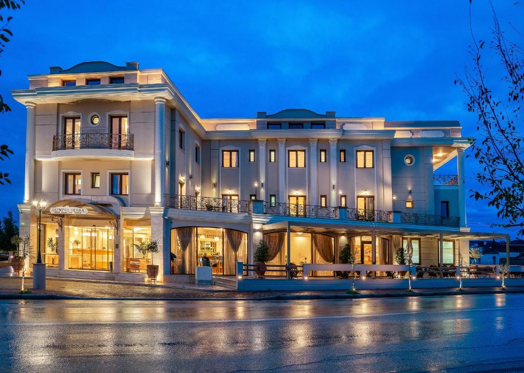 - un grand bâtiment blanc la nuit dans l'établissement Olympus Terra Boutique Hotel, à Larissa