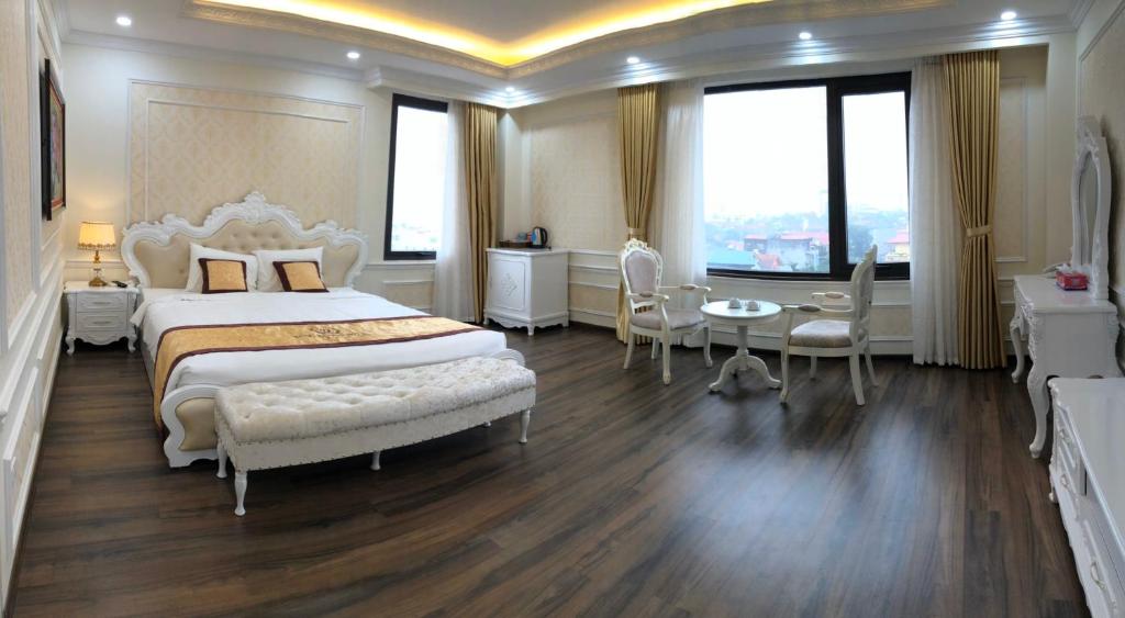 1 dormitorio con 1 cama, mesa y sillas en Tung Duong Hotel en Thái Nguyên