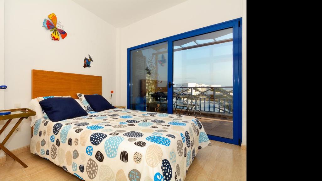 1 Schlafzimmer mit einem Bett und einem Balkon mit einem Schmetterling an der Wand in der Unterkunft Apartment La Marina Sea Views with terrace By PVL in Arrecife