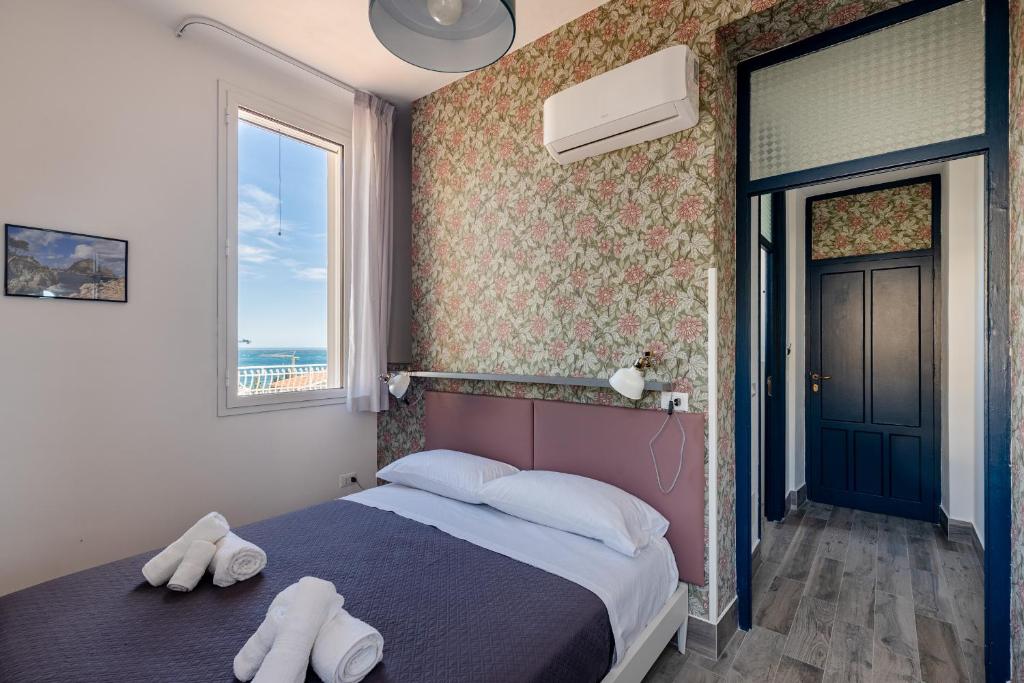 a bedroom with a bed with two white towels on it at Villa Edera Rental Room in Santa Flavia