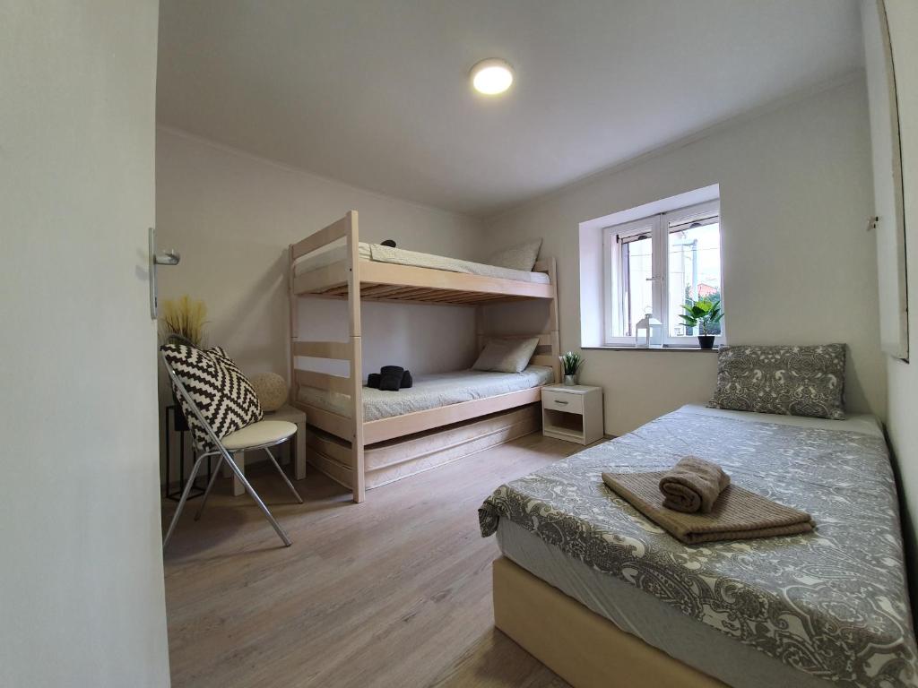 sypialnia z 2 łóżkami piętrowymi i krzesłem w obiekcie Guest House Novalja w Novalji