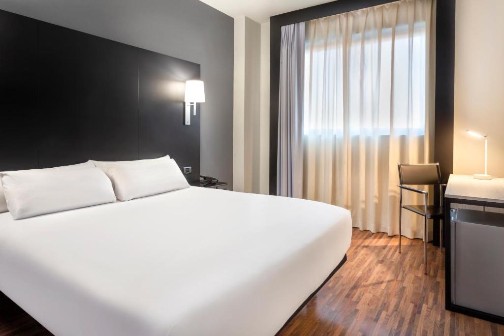 duże białe łóżko w pokoju z oknem w obiekcie B&B HOTEL Madrid Getafe w mieście Getafe