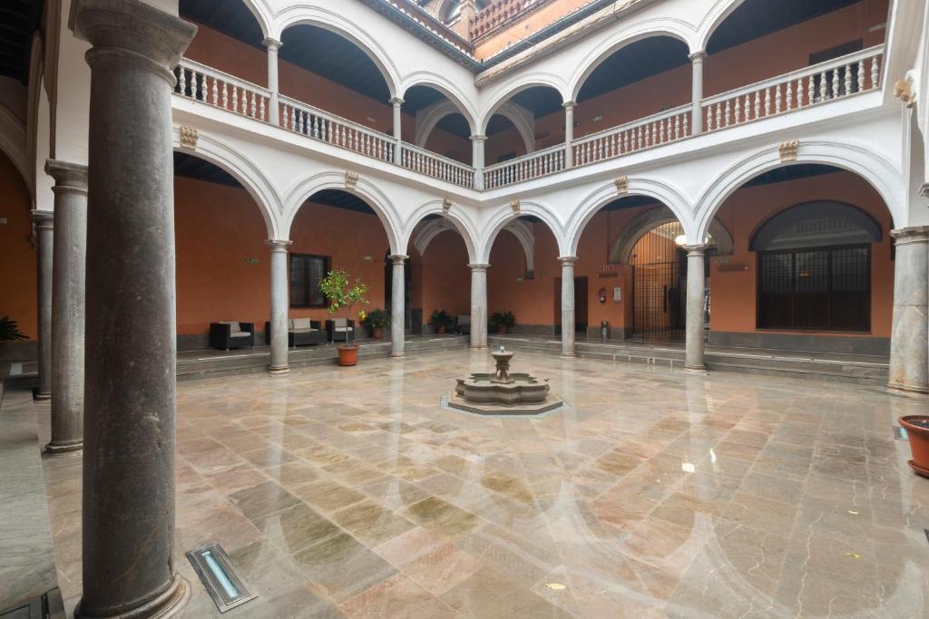 un vestíbulo con una fuente en medio de un edificio en APARTAMENTOS PALACIO DE LOS JERÓNIMOS free parking, en Granada