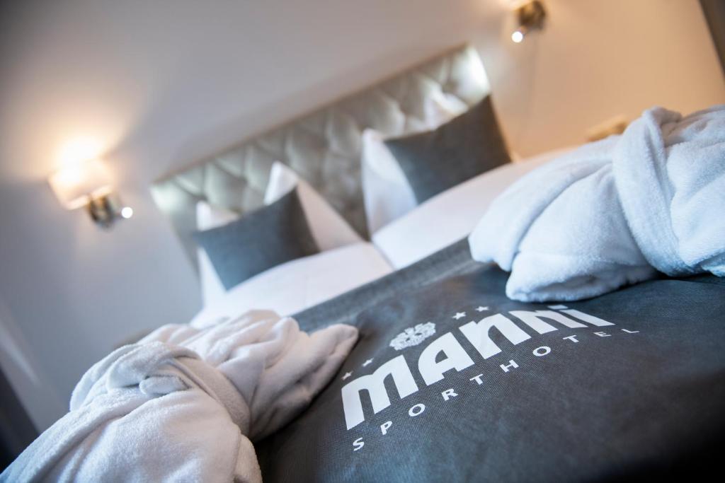 un hombre está sosteniendo un libro en una cama en MANNI home - rooms & apartments en Mayrhofen