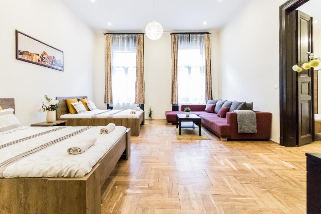 sala de estar con 2 camas y sofá en Real Apartments Klauzál, en Budapest