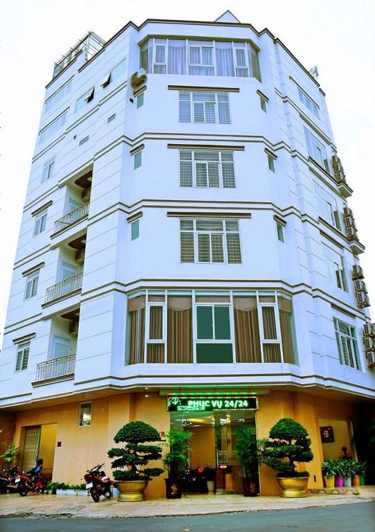 a large white building with trees in front of it at Khách Sạn Hiệp Thạnh in Buon Ma Thuot