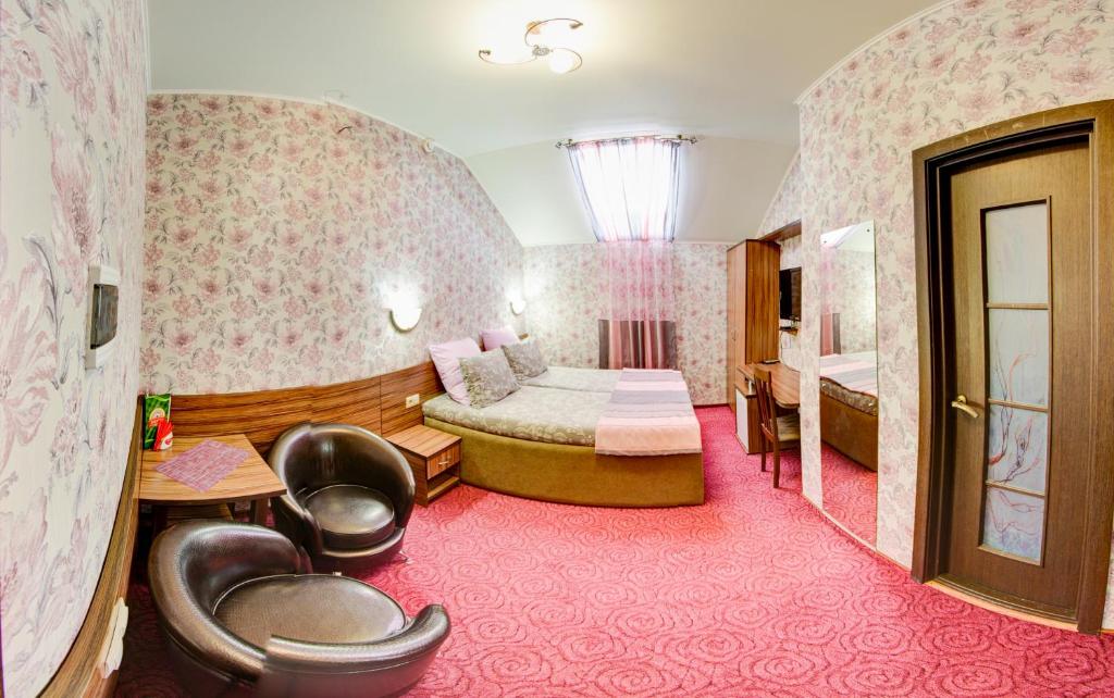 Habitación de hotel con cama y silla en Zvezda Guest House, en Saratov