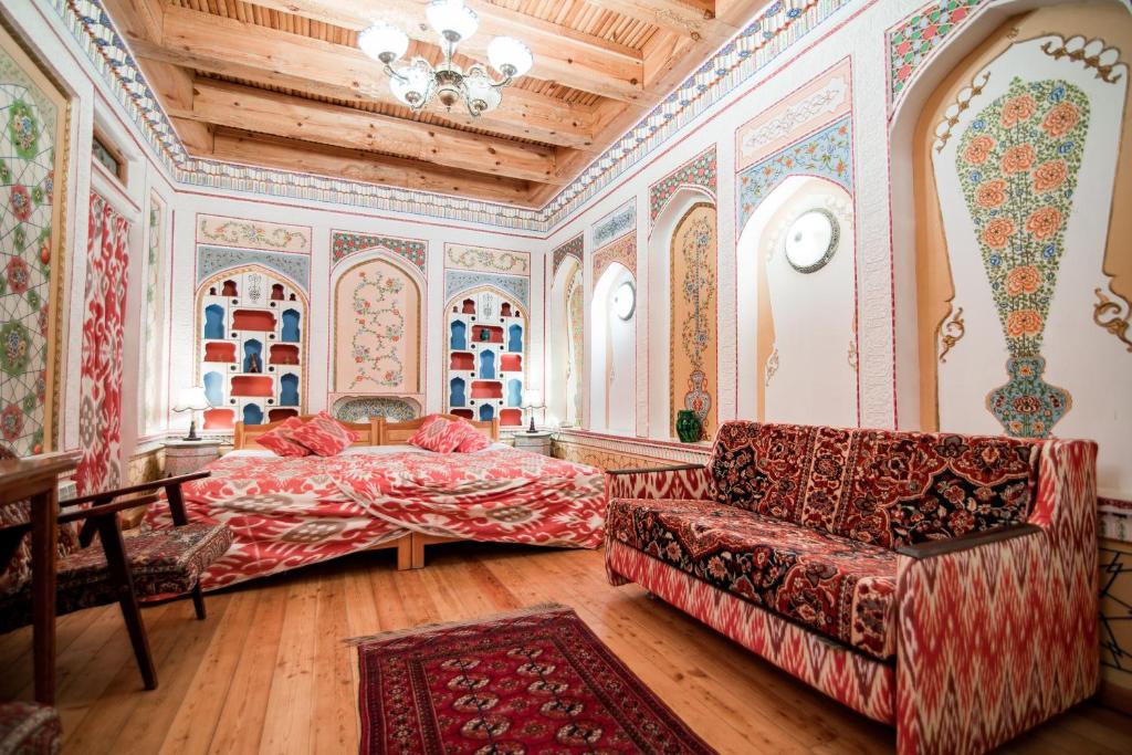 - un salon avec un lit et un canapé dans l'établissement Boutique Hotel Minzifa, à Boukhara
