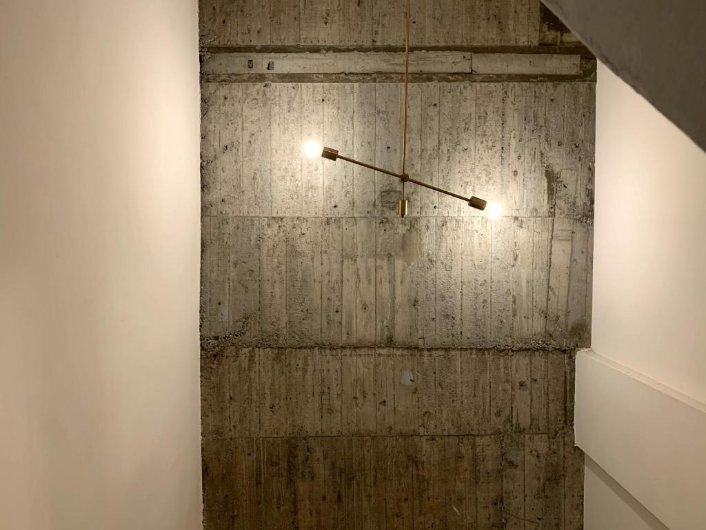 a clock hanging on a concrete wall in a room at PlainStay Hostel in Taipei