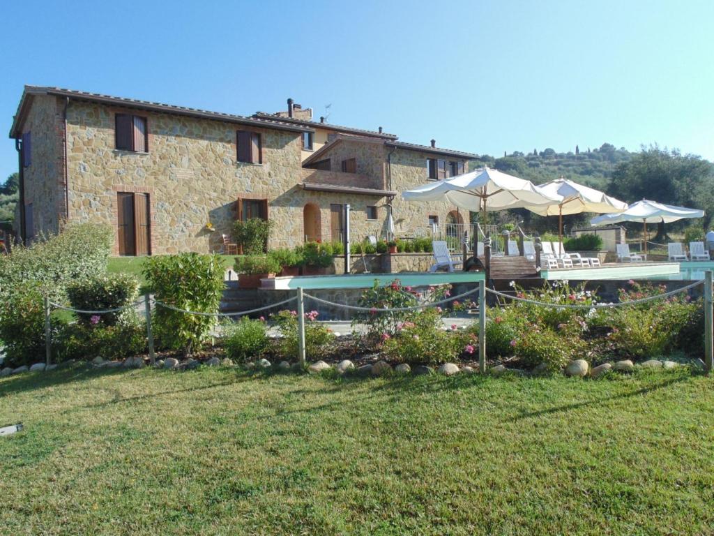 a building with a pool in front of a yard at Il Borgo sul Lago in Monte del Lago