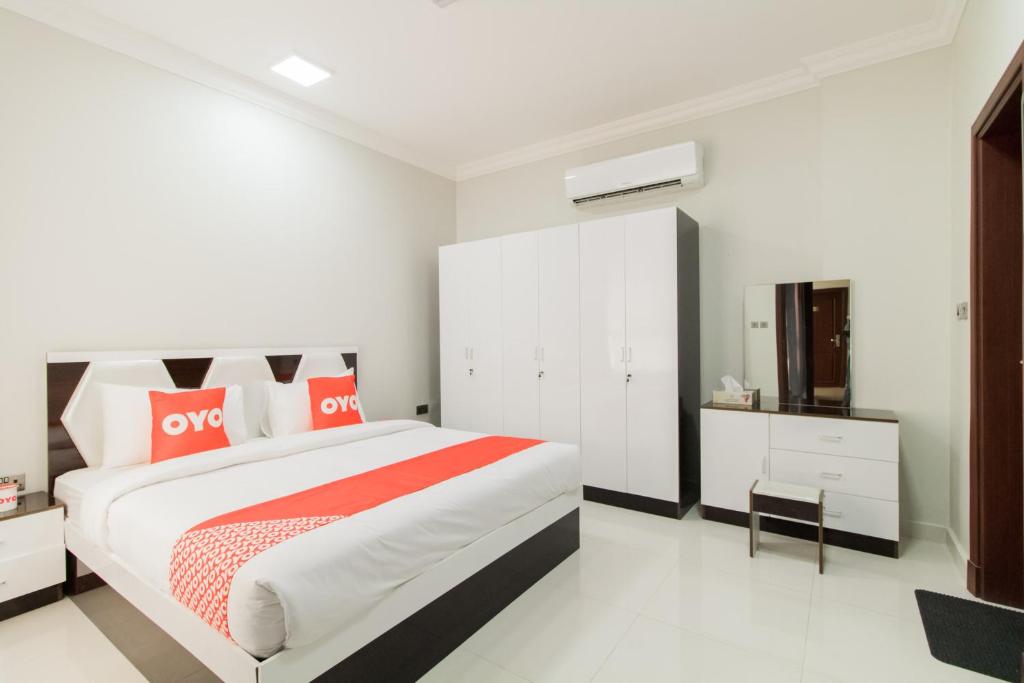 a bedroom with a large bed with red and white pillows at Super OYO 106 Muscat Grand Hotel Apartment in Seeb