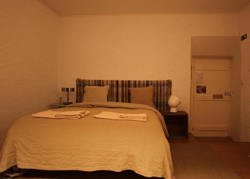 a bedroom with a large bed with two towels on it at ribeira dos marinheiros amarelo in Sintra