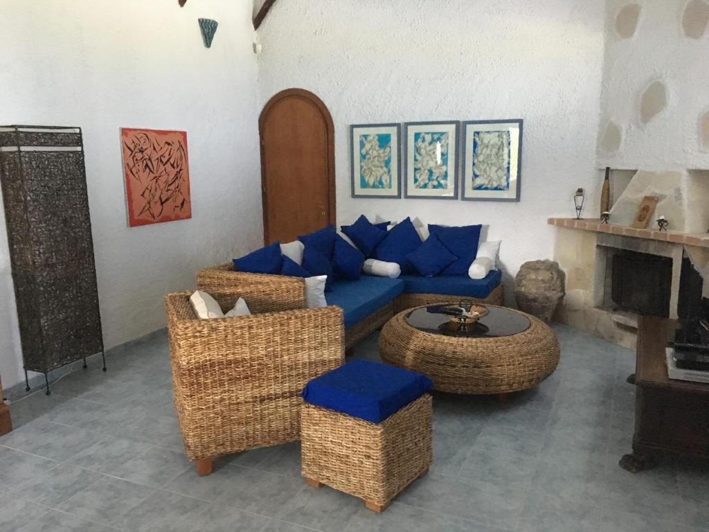 トロペアにあるVilla Paradisoのリビングルーム(青いソファ、籐の椅子付)