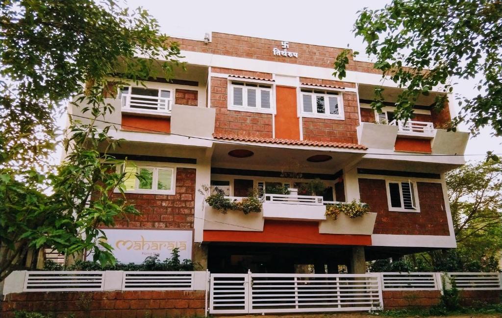 a building with white windows and balconies at Maharaja Home Stay Panhala in Panhāla