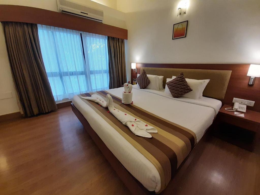 Postel nebo postele na pokoji v ubytování Hotel Phoenix Koregaon Park