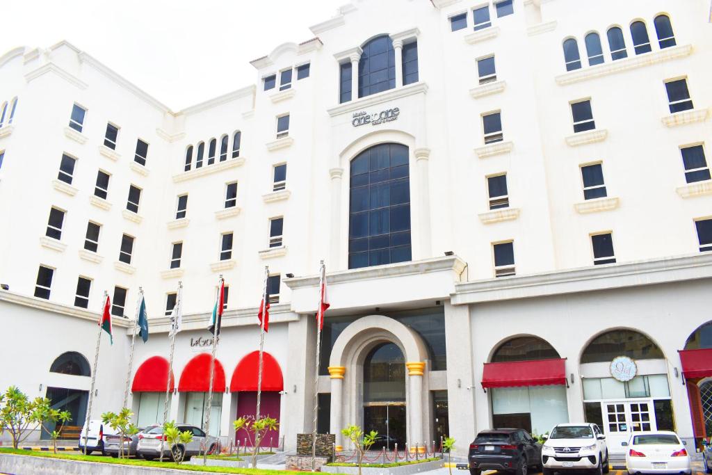 a white building with flags in front of it at One to One in Al Khobar