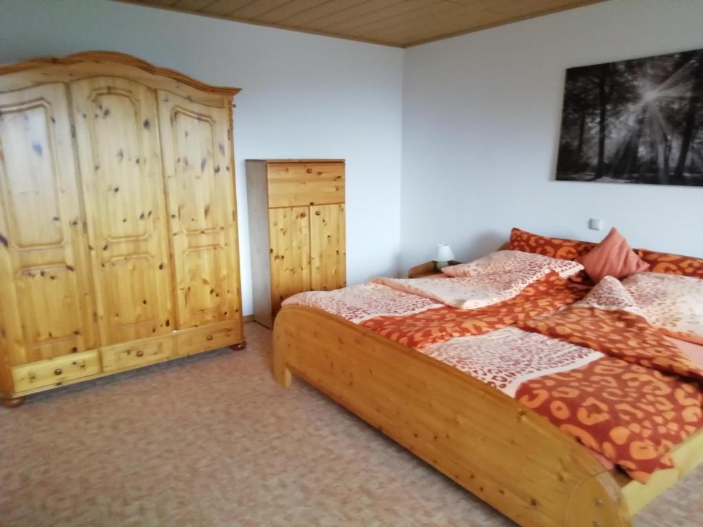 1 dormitorio con 1 cama y armario de madera en Ferienwohnung Uschkereit, en Waldmünchen