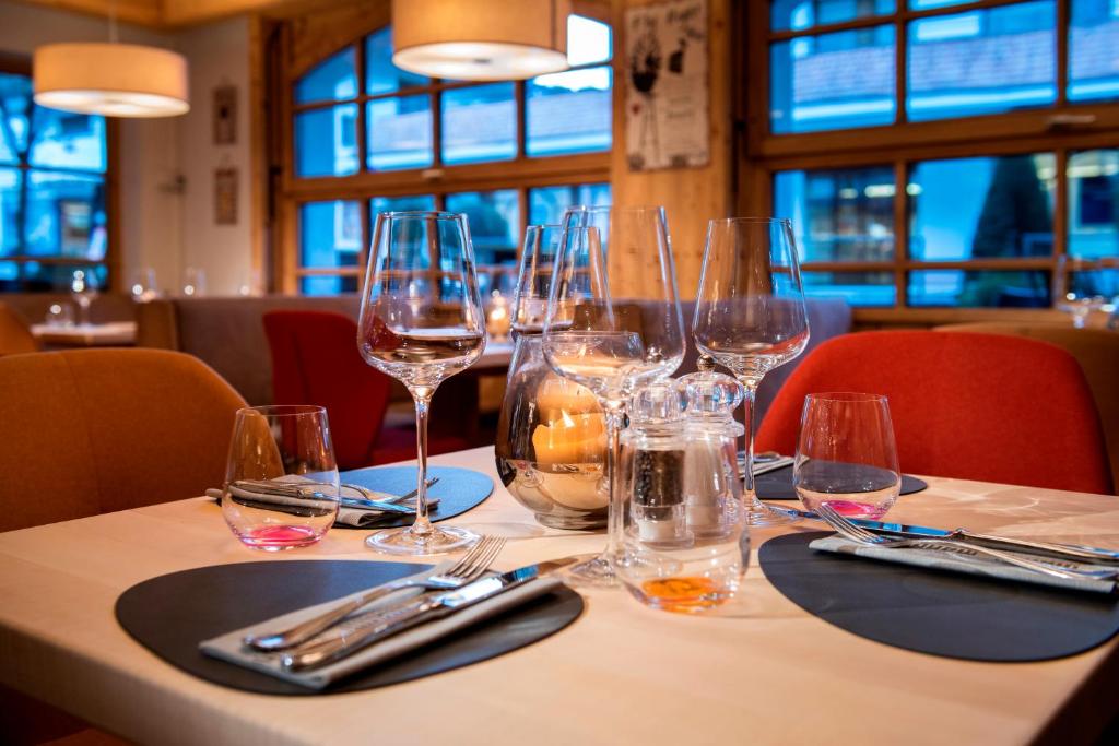 a table in a restaurant with wine glasses on it at MANNI das Hotel in Mayrhofen