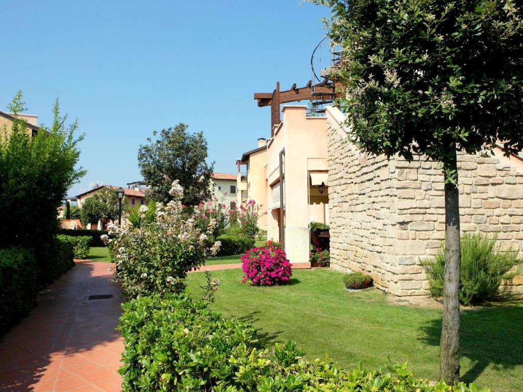 einen Garten mit rosa Blumen und einem Gebäude in der Unterkunft Well-kept ground floor apartment near Peschiera in Peschiera del Garda