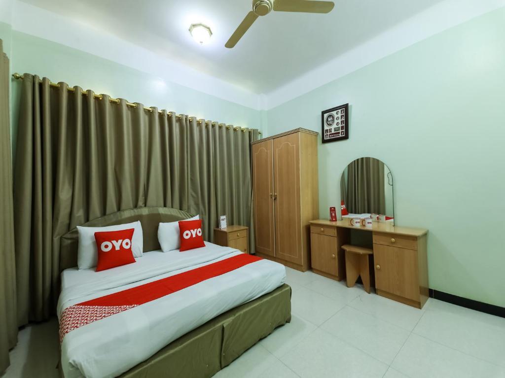 Super OYO 108 Marsa Al Masafar Hotel Apartment في صور: غرفة نوم بسرير كبير ومرآة