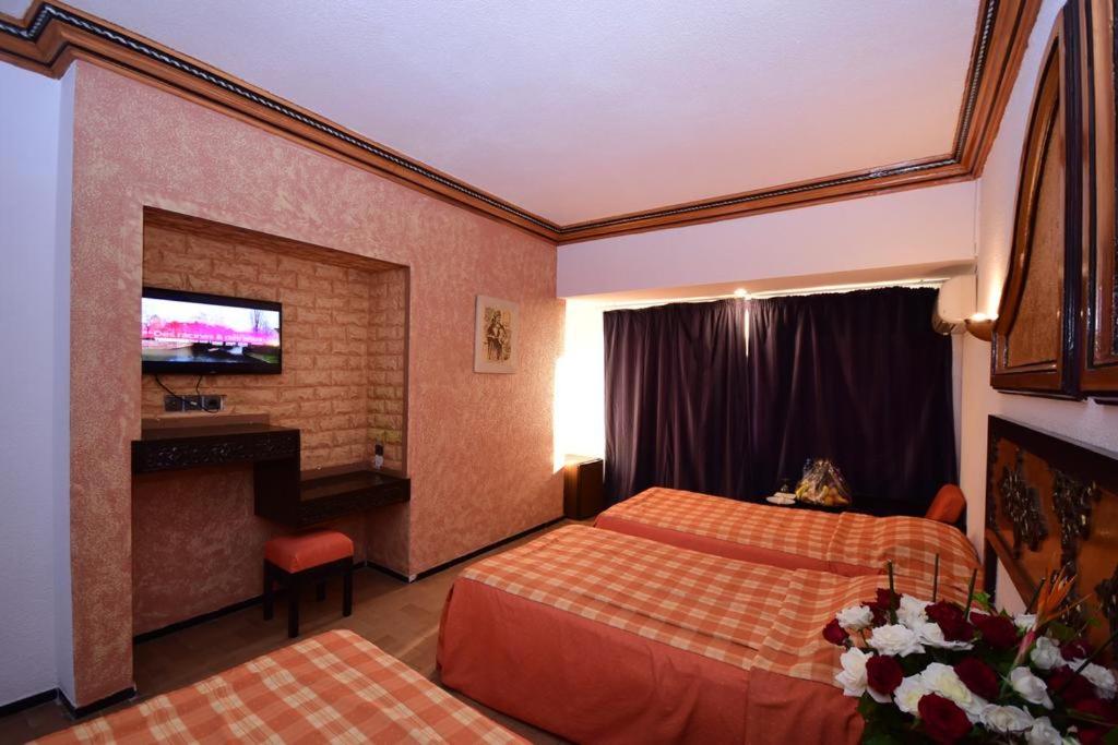 a hotel room with two beds and a television at Sud Bahia Agadir "Bahia City Hotel" in Agadir