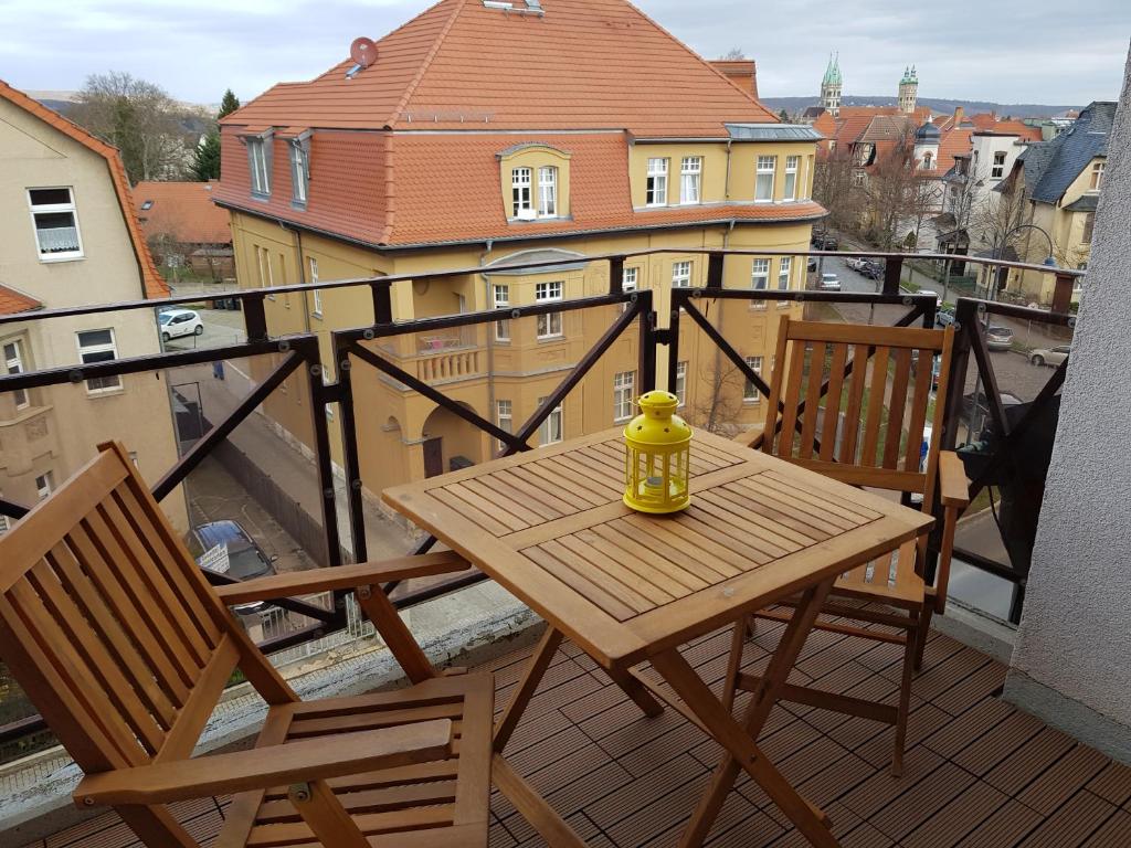 - Balcón con mesa de madera y 2 sillas en Ferienwohnung mit Domblick, en Naumburg