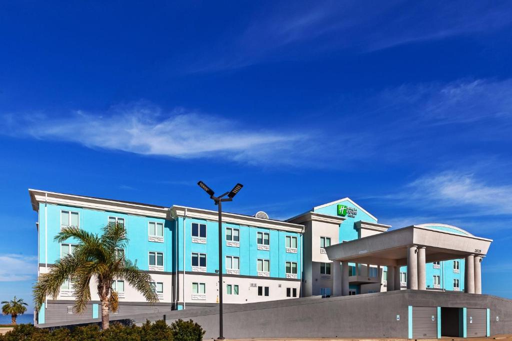 a large blue building with a palm tree in front of it at Holiday Inn Express Port Lavaca, an IHG Hotel in Port Lavaca