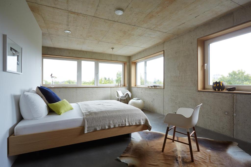 ein Schlafzimmer mit einem großen Bett und zwei Fenstern in der Unterkunft ipartment Cologne Muelheim in Köln