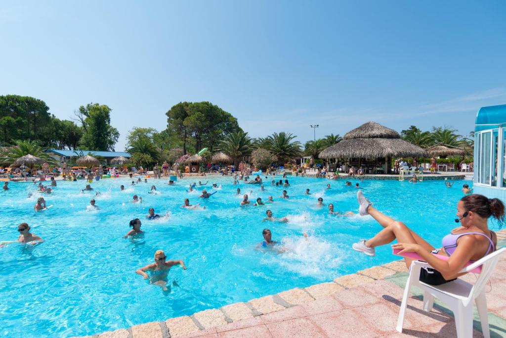 um grupo de pessoas na piscina de um resort em Camping Village Pino Mare em Lignano Sabbiadoro