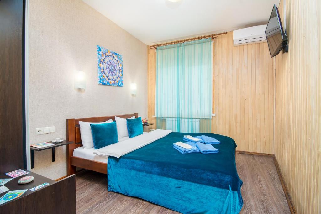 a hotel room with a bed with blue sheets at Mini-Hotel Ocean in Kyiv