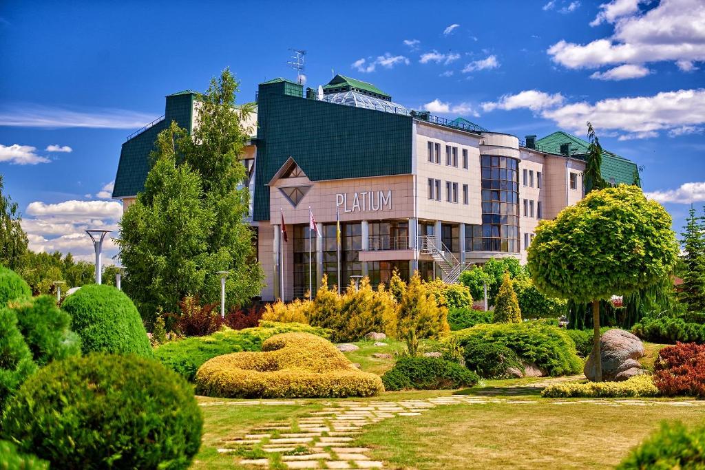um hotel com um jardim em frente a um edifício em Platium Spa&Resort em Kozin