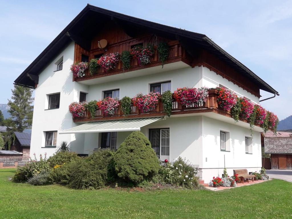 a white house with flower boxes on the balcony at Schusterbauernhof in Bad Mitterndorf