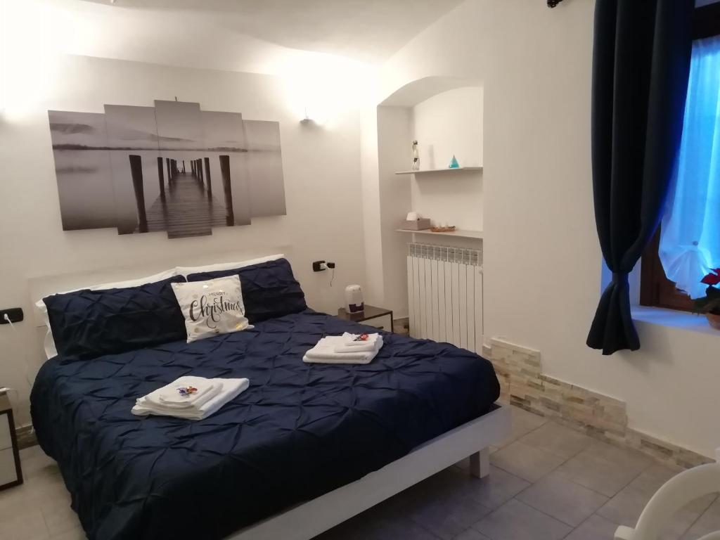 a bedroom with a blue bed with towels on it at La Poesia del Lago in Oggiono