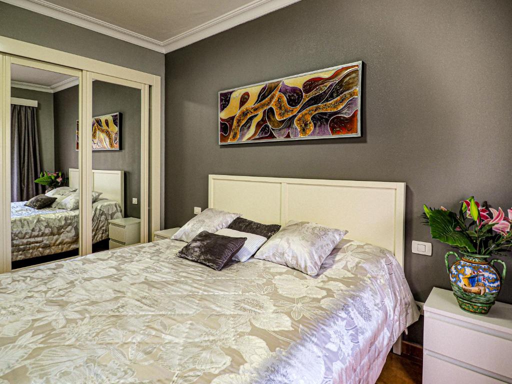 sypialnia z łóżkiem i obrazem na ścianie w obiekcie Perfect Apartment w Puerto de la Cruz
