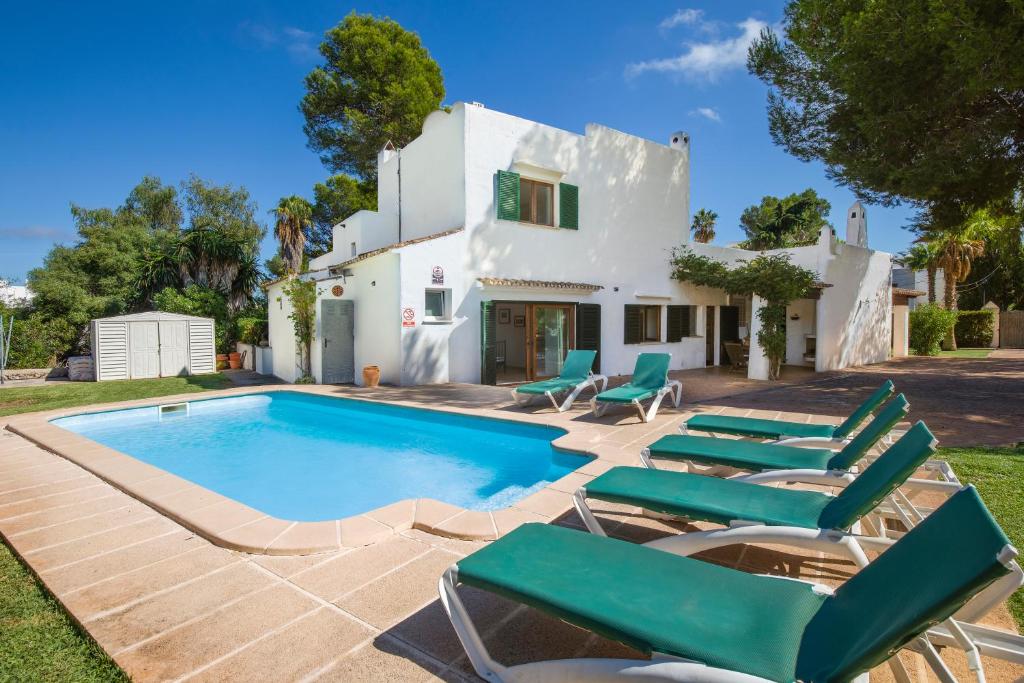 a villa with a swimming pool and lounge chairs at Villa Mumare in Cala d´Or