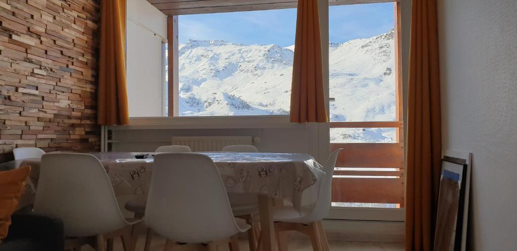 a table and chairs with a view of a mountain at Triplex E12 Résidence Les Lauzes - Les Menuires - Croisette in Les Menuires