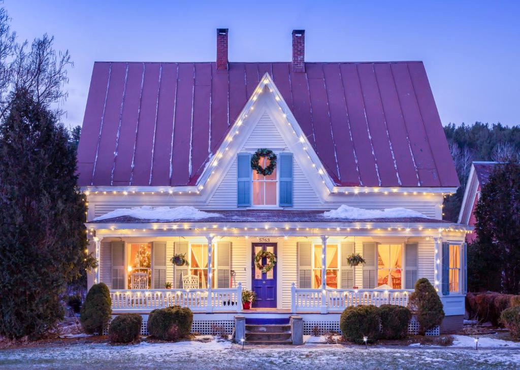 a house with christmas lights on the porch at Woodbridge Inn Bed & Breakfast in Woodstock