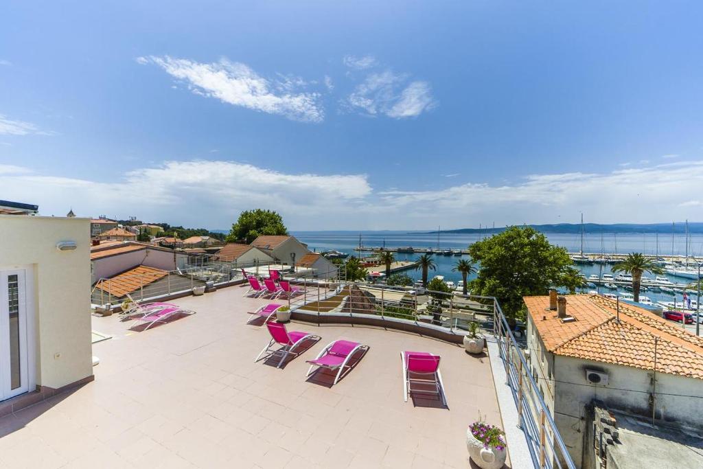 a balcony with pink chairs and a view of the water at Luxur house with seaview teracce in Baška Voda